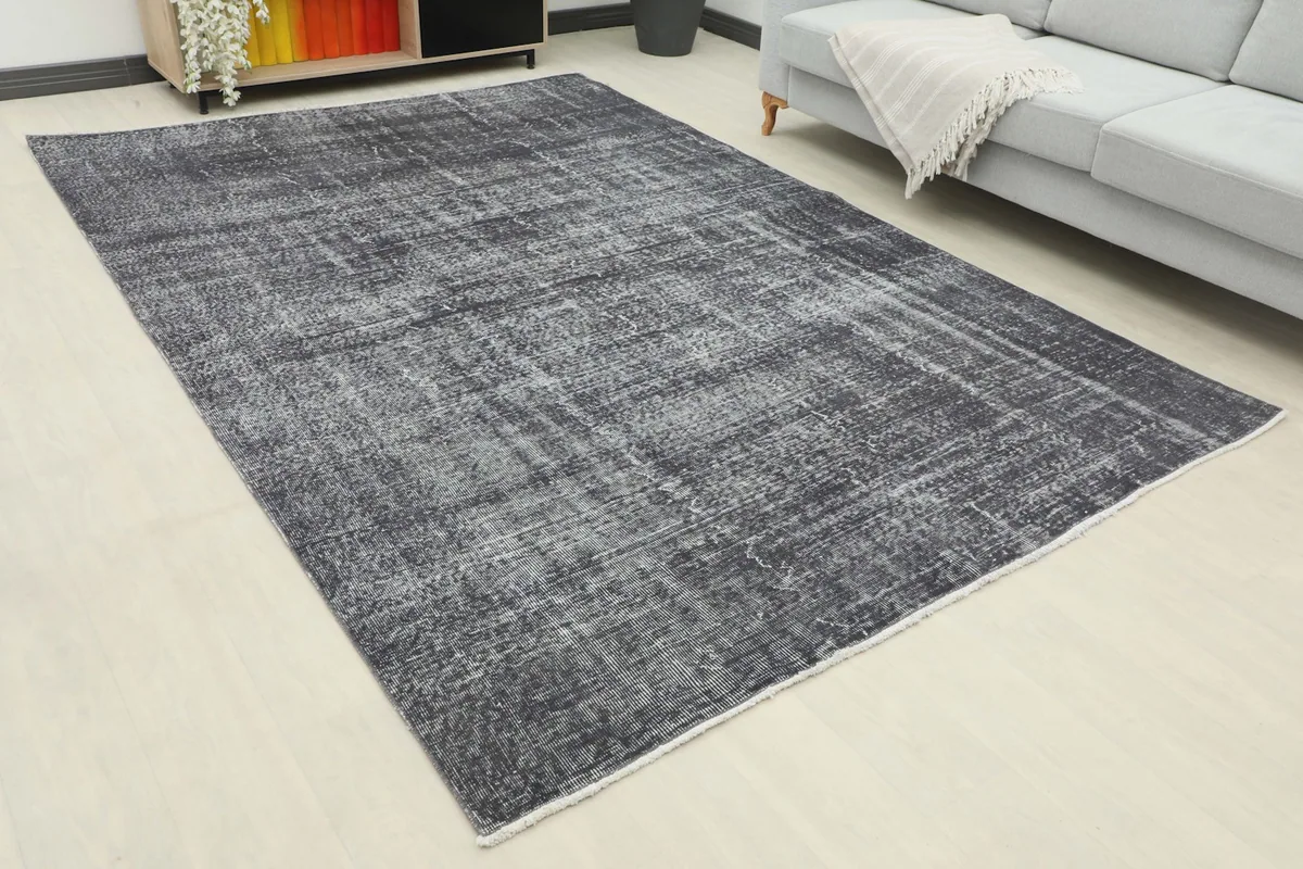 Overhead view of the distressed charcoal rug in a living room, showing its placement relative to the sofa.