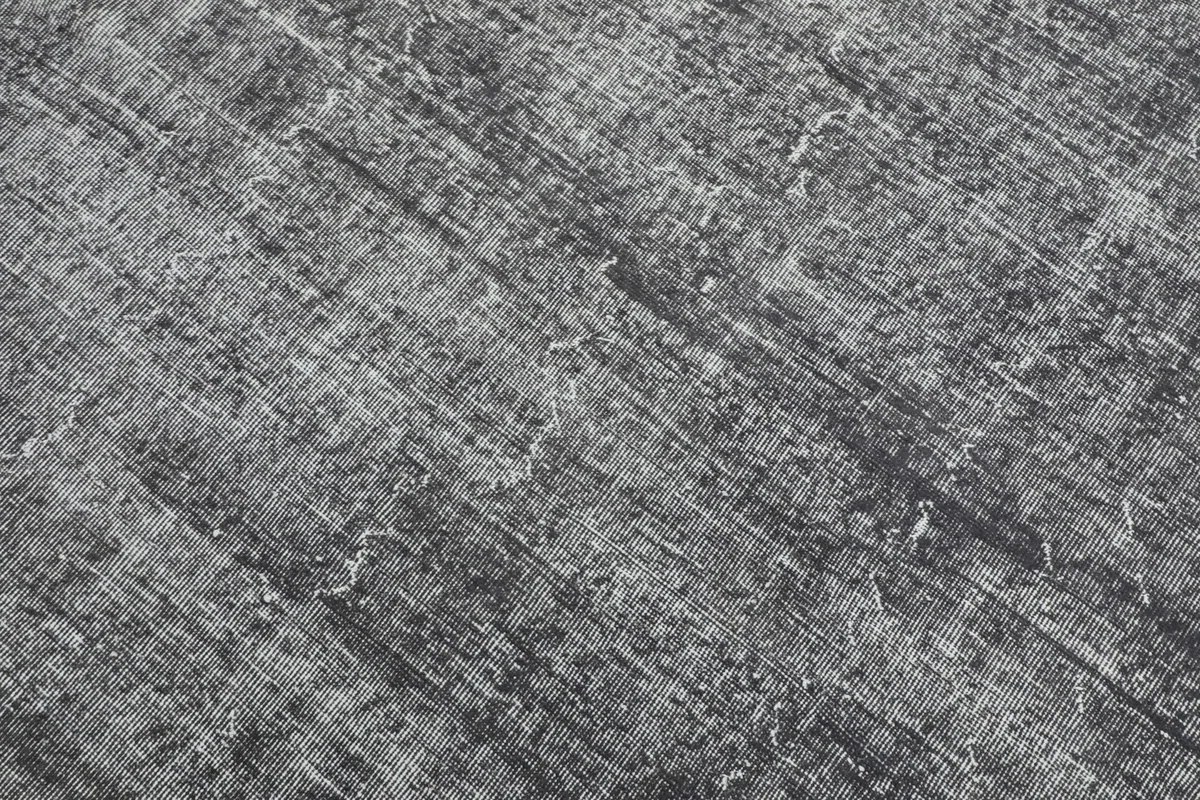 Detailed close-up of the rug's surface, revealing the subtle geometric pattern and color fading.