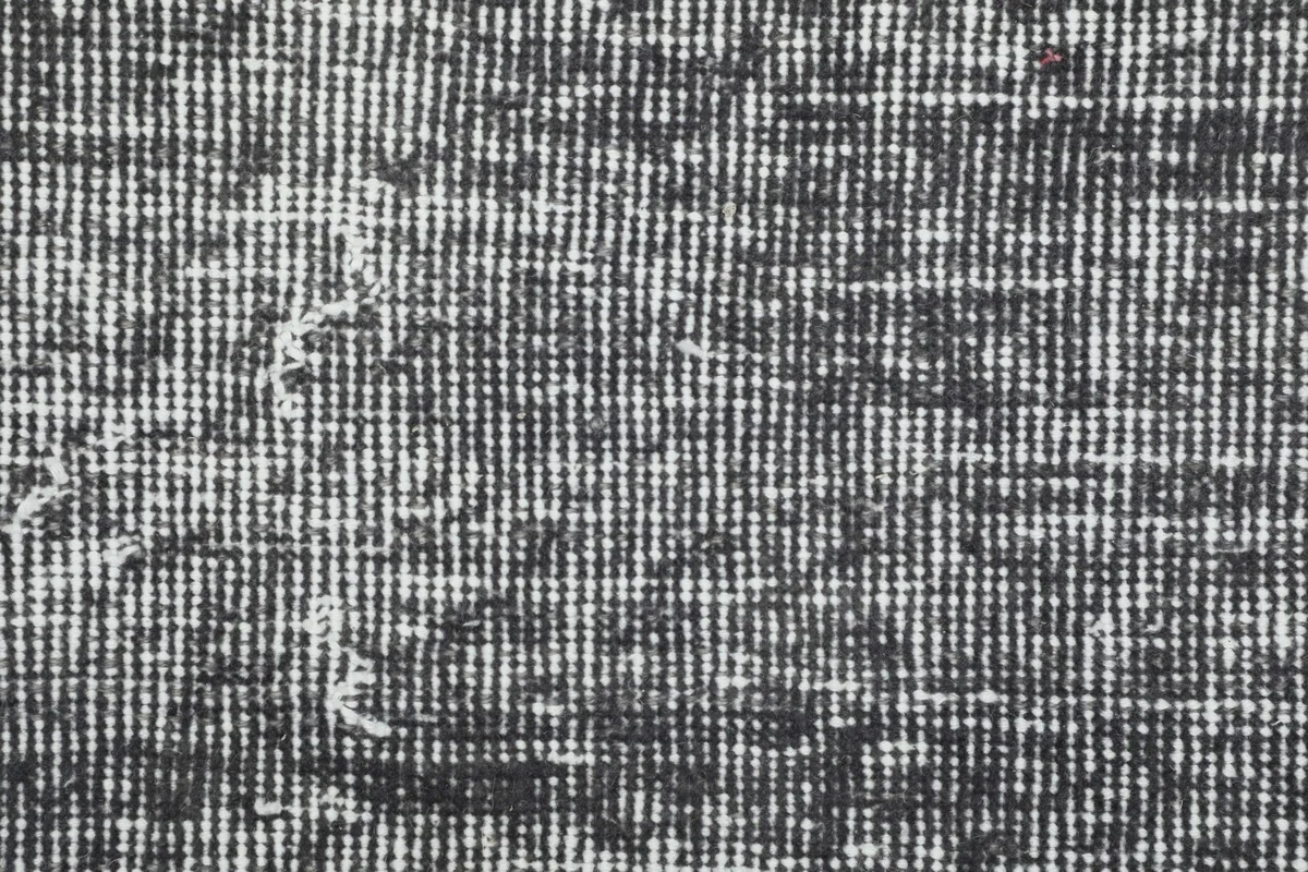 Extreme close-up of the low wool pile, showing the individual knots and distressed fibers.