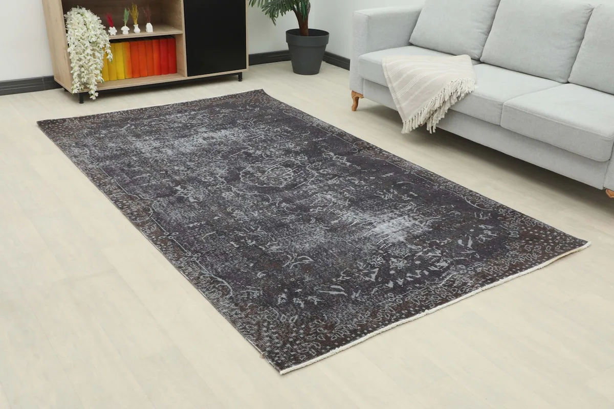 Angle view of the charcoal geometric rug in a living room, showing its placement relative to furniture