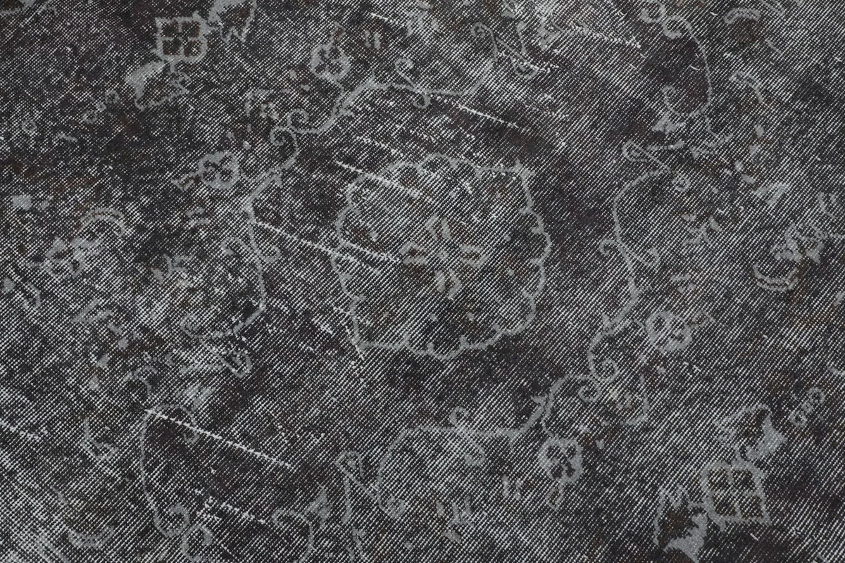 Detailed view of the rug's surface, showing intricate faded floral and geometric motifs