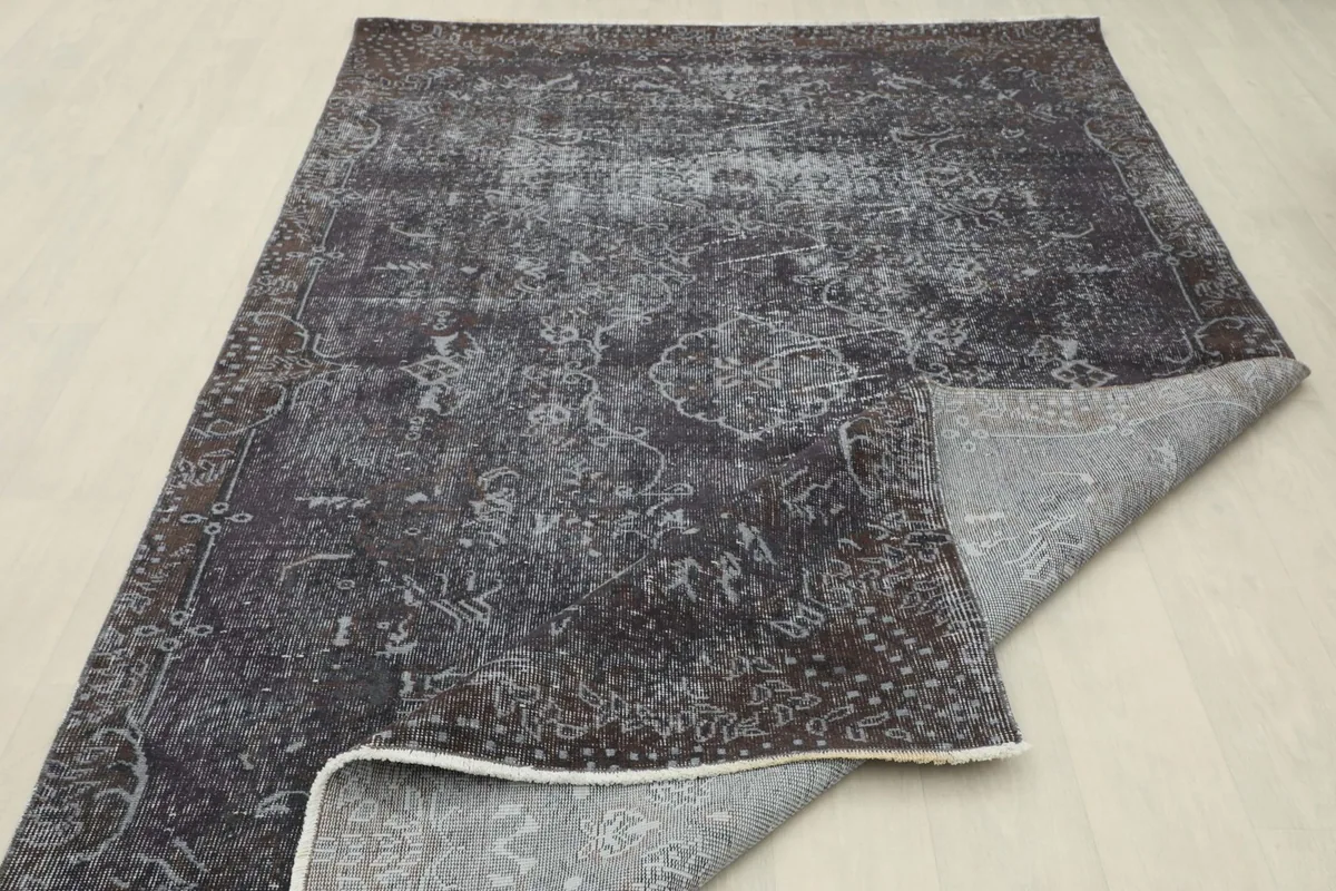 The rug partially folded over, showcasing its flexibility and the overall distressed pattern