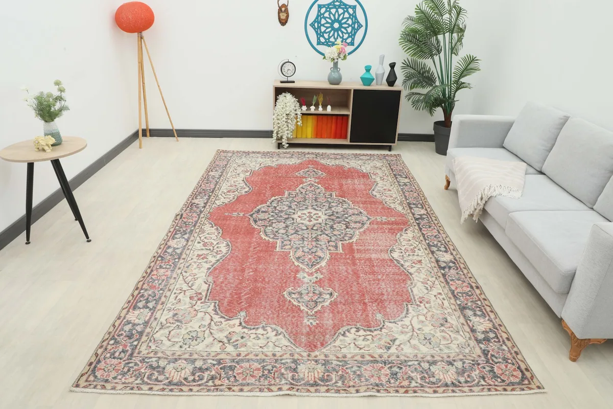 Full overhead view of the vintage rust and navy rug in a room, demonstrating its size and placement.