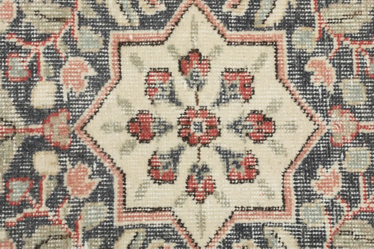 Extreme close-up of the medallion's star-shaped center, showing individual knots and subtle color variations.