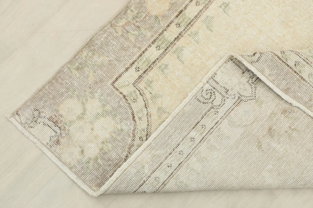 Corner of the rug folded to show the hand-knotted wool pile and cotton foundation