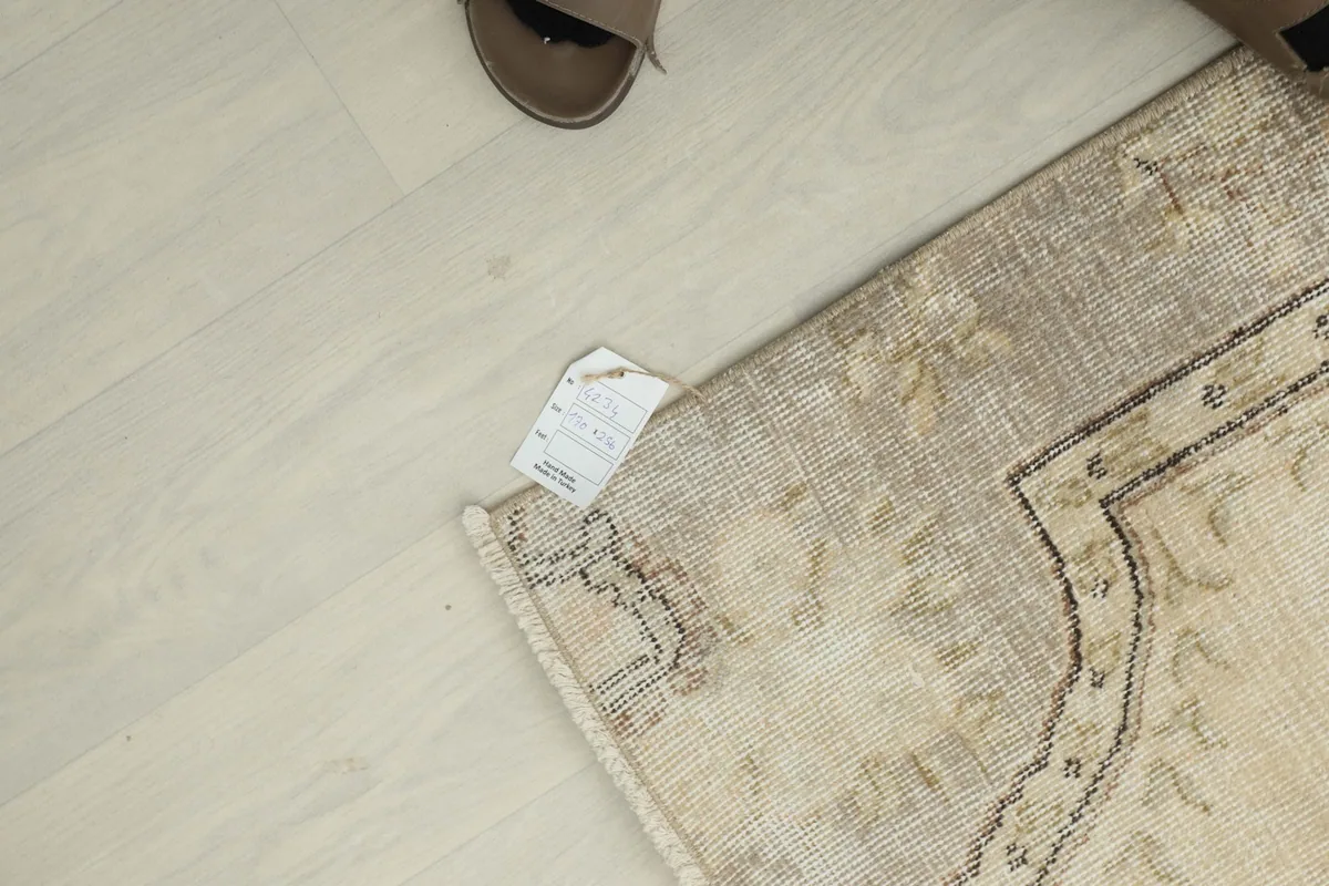 Overhead view of a corner of the rug with a size tag visible