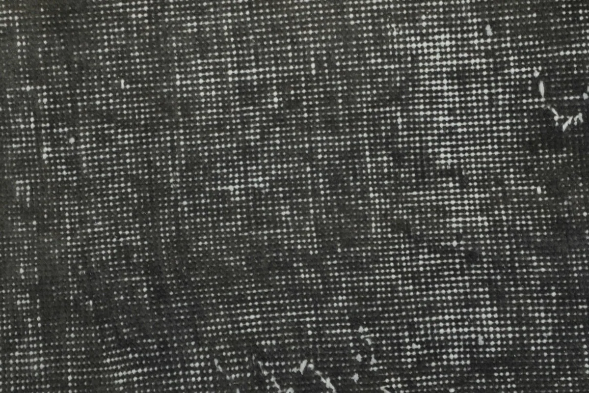 Very close detail of the hand-knotted wool pile and cotton foundation visible through wear