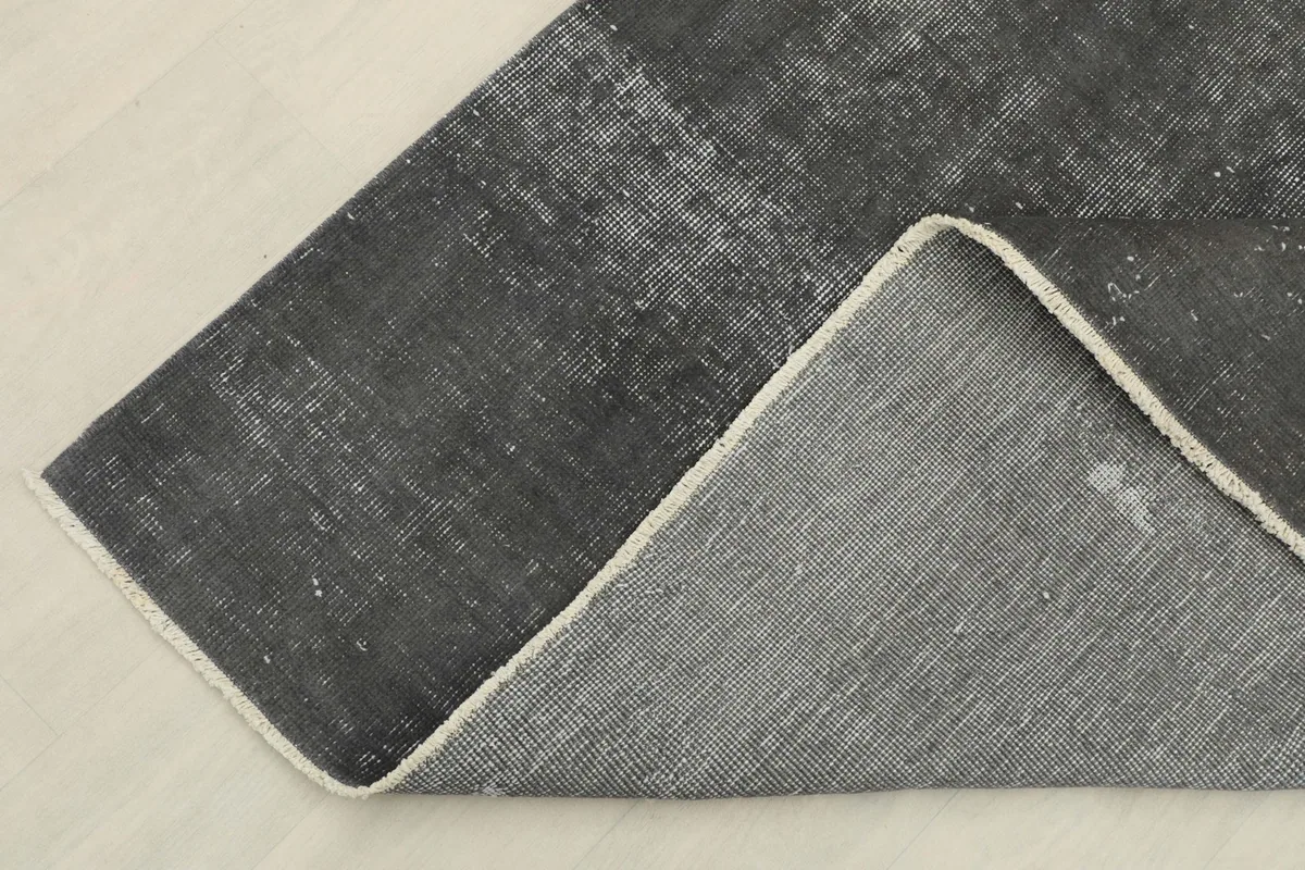 Close-up of the rug's reverse side and the visible hand-knotted cotton foundation