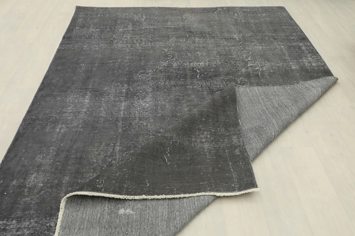 Rug corner folded back, revealing the reverse side of the hand-knotted wool on cotton