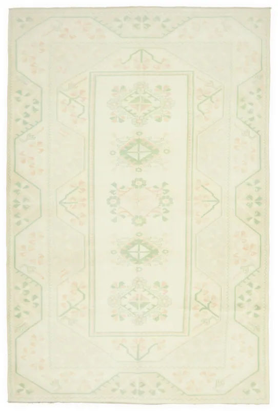 Full top view of the vintage ivory rug with green and rose geometric and floral patterns.