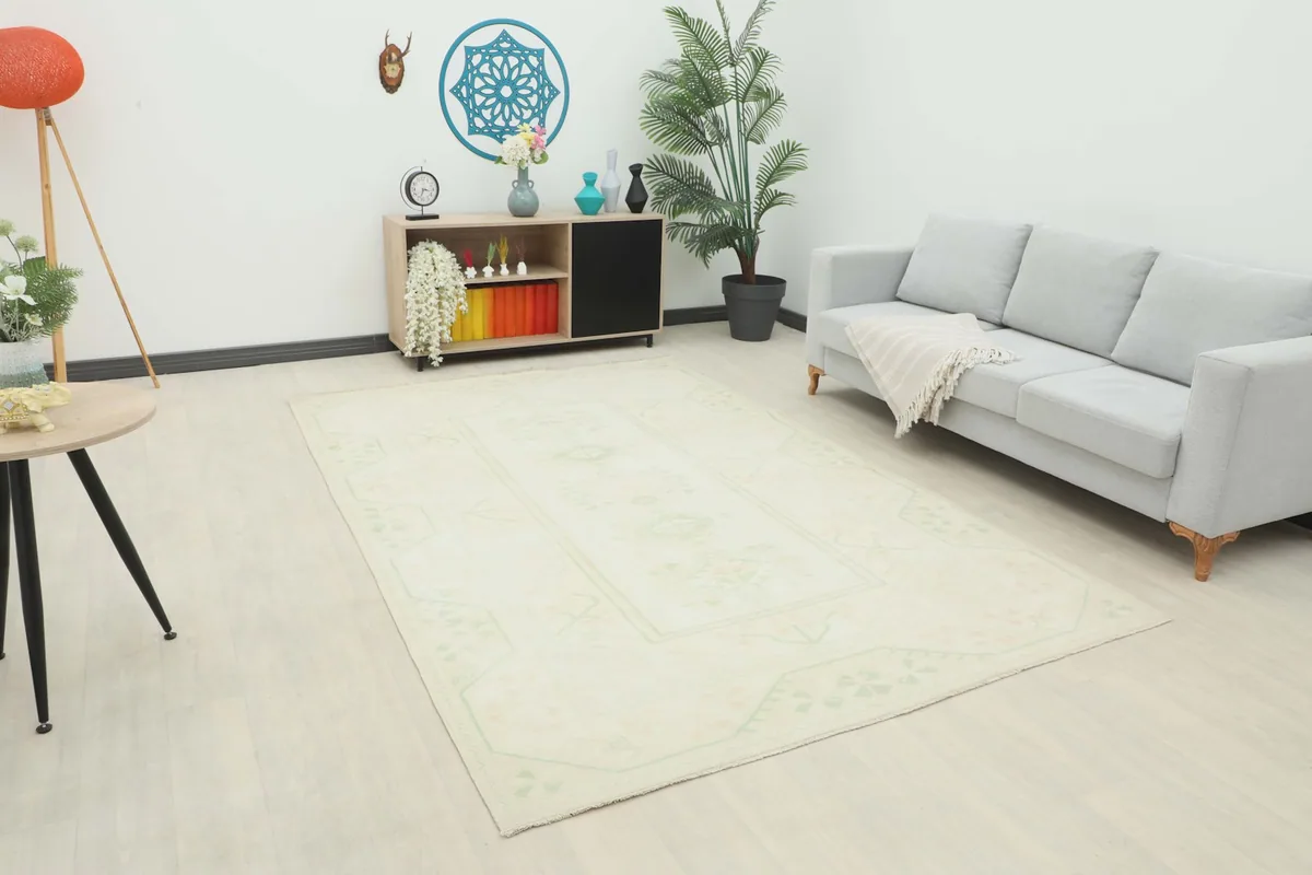 Ivory rug placed in a bright living room setting with a light gray sofa and modern decor.