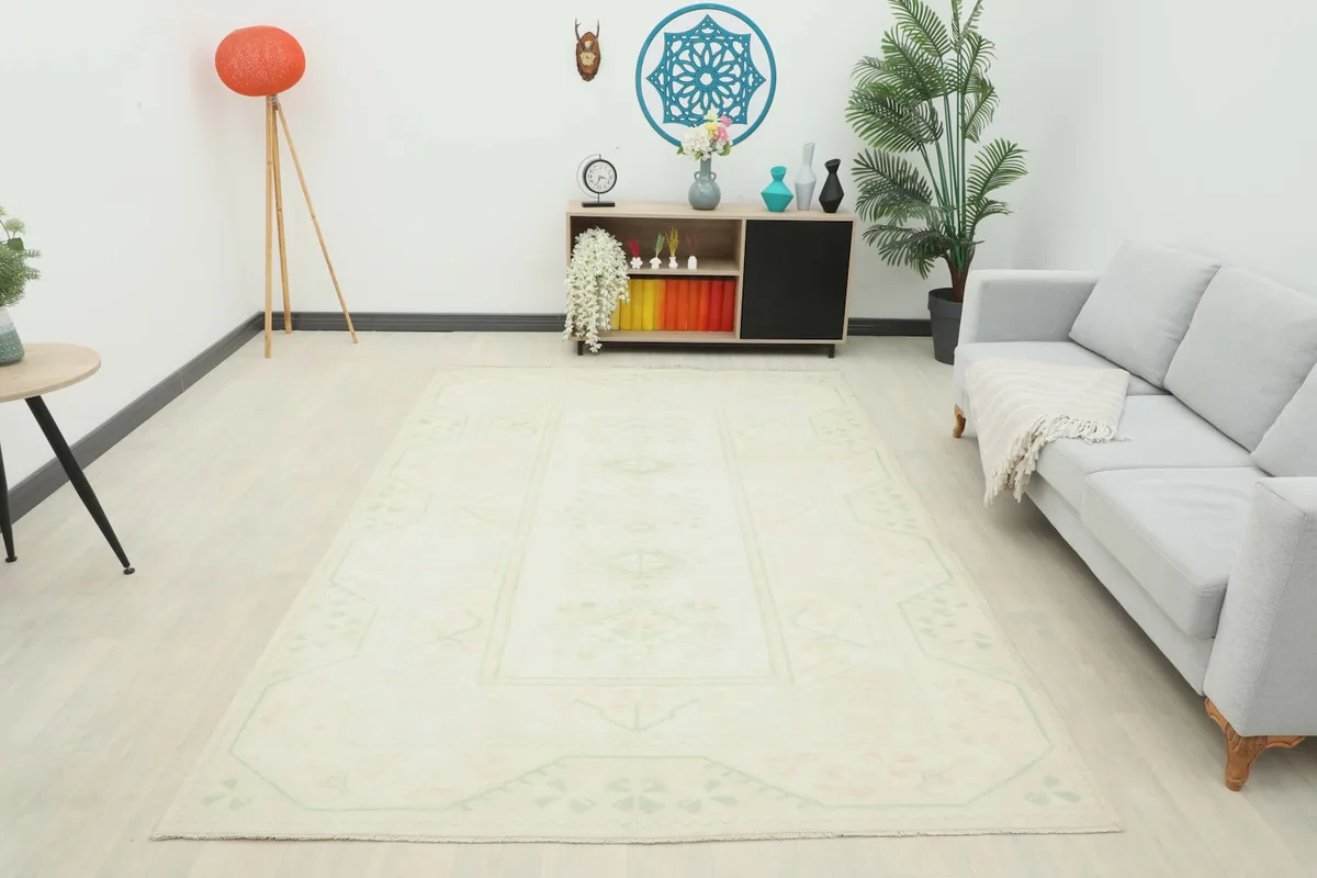 Wide shot of the ivory rug enhancing a modern living space with a light sofa and colorful accents.