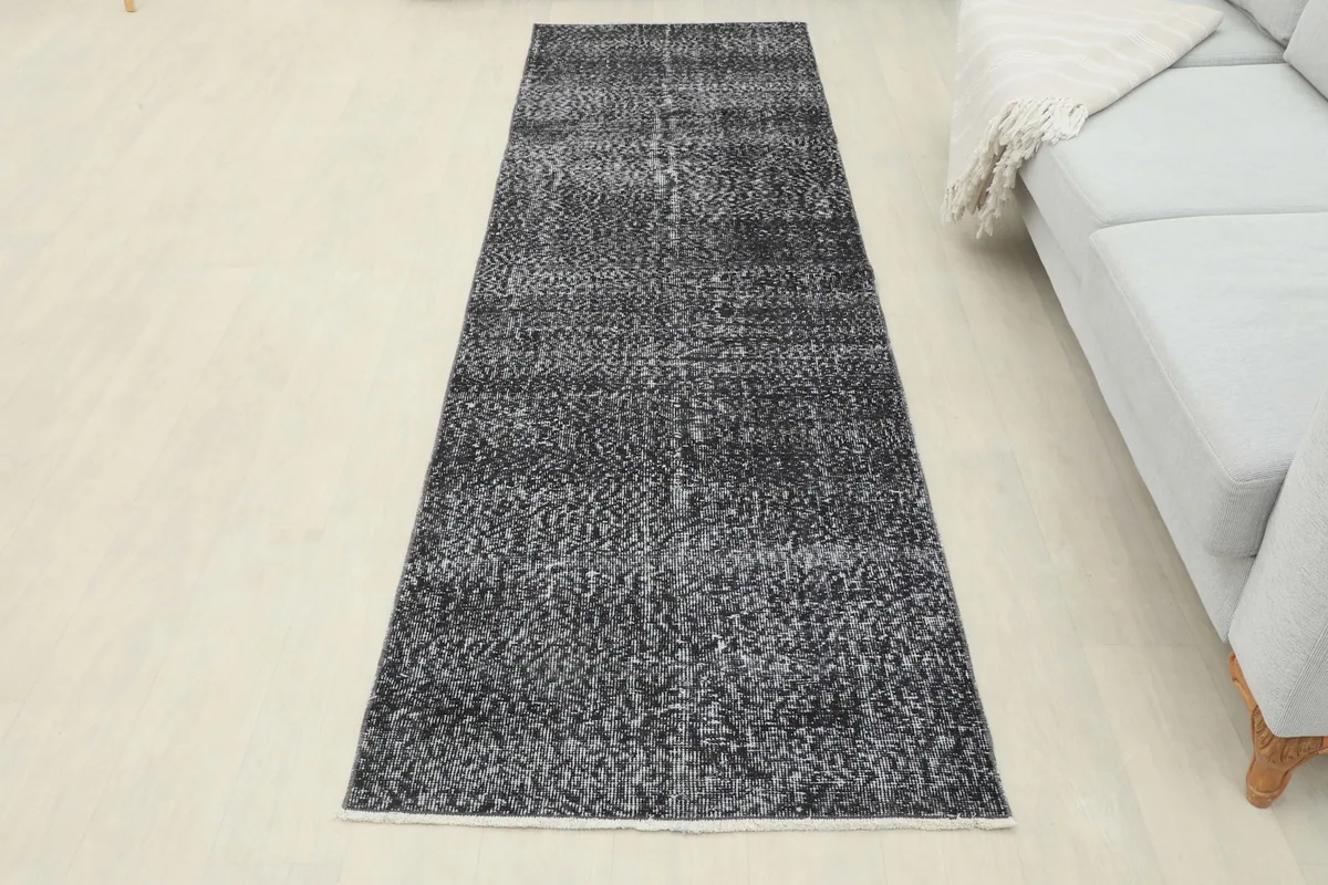 Full view of the charcoal gray runner rug laid out in a room, offering a complete perspective of its size and design.