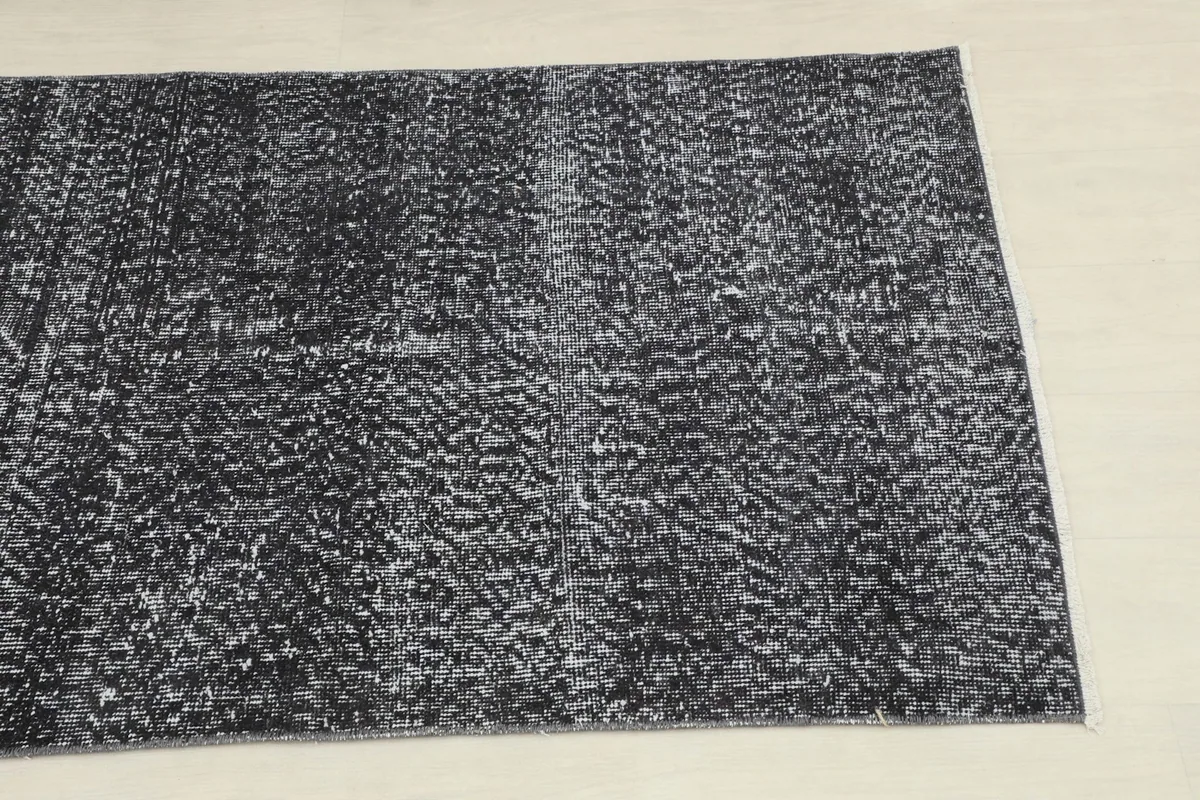 Close overhead shot of a section of the runner rug, revealing the distressed charcoal and gray tones.