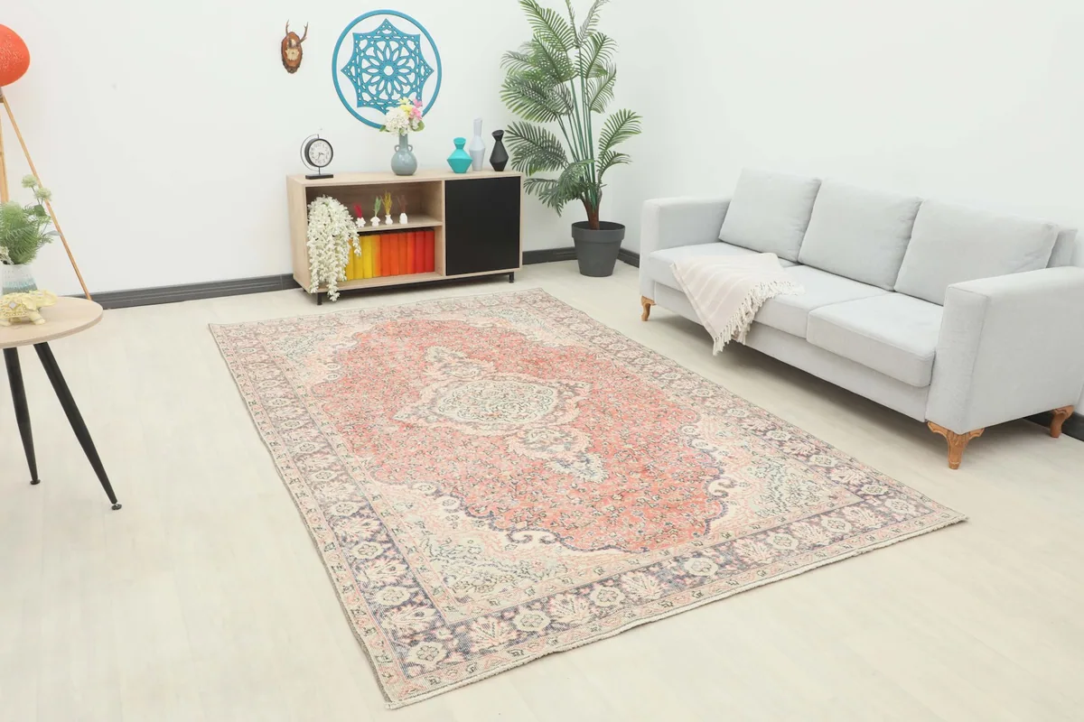 Vintage rust medallion rug placed in a modern living room setting with a light gray sofa.