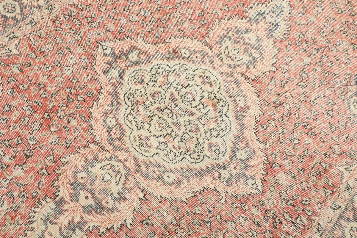 Detailed view of the central medallion, featuring beige and navy patterns on a rust background.