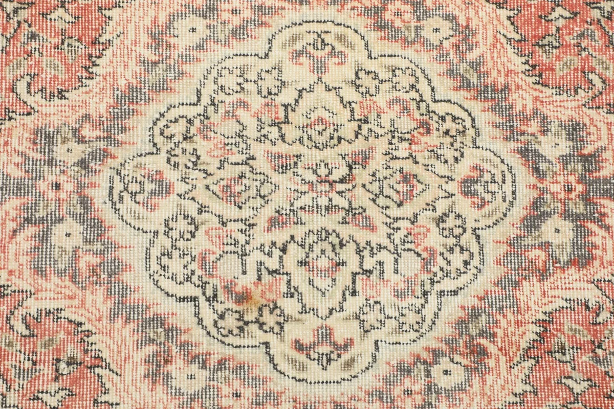 Close-up of the medallion's intricate floral and geometric patterns with faded colors.
