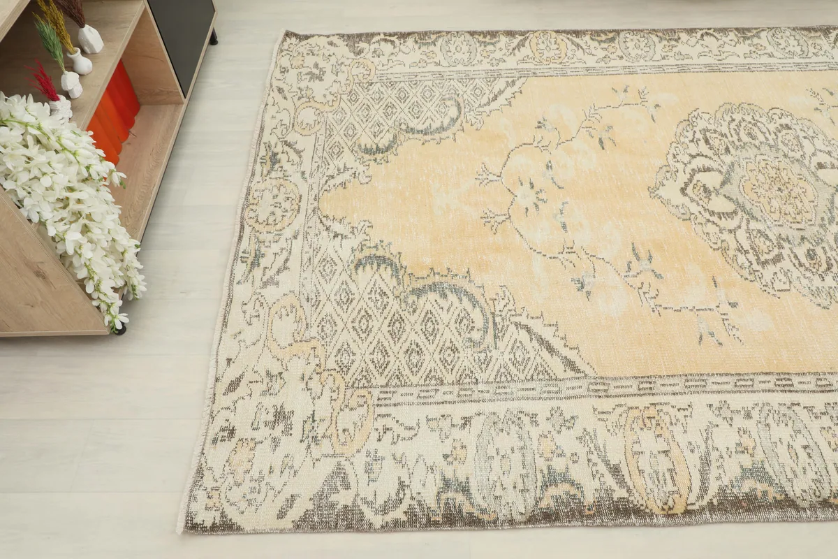 Beige Medallion Anatolian Rug viewed from another angle, showing the distressed texture and color variations.