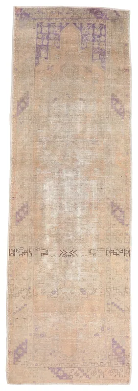 Full overhead view of the beige and purple vintage Anatolian runner rug on a white background