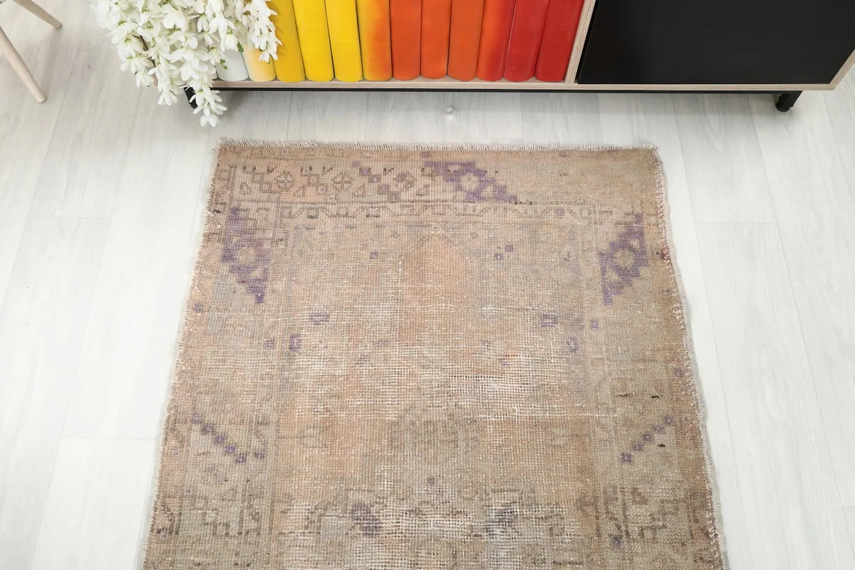Top-down view of the rug's pattern distribution and color fading near a cabinet