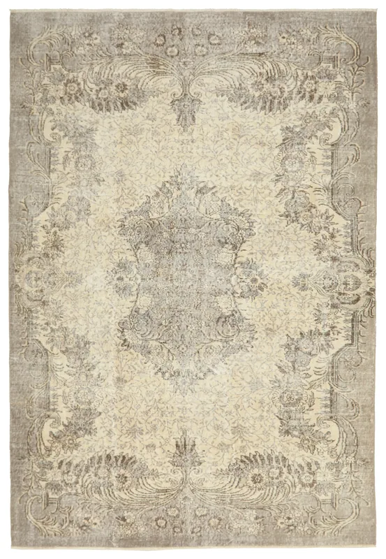 Full top view of an ivory and charcoal floral medallion vintage Anatolian area rug on a white background.
