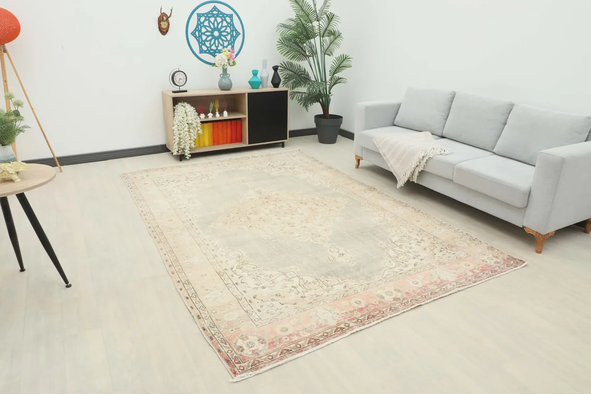 Vintage Anatolian rug displayed in a living room setting with a gray sofa and wooden furniture