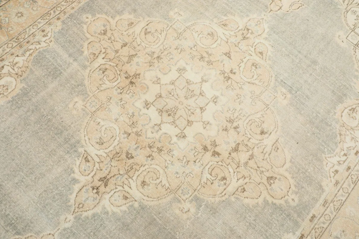 Close-up detail of the central beige medallion and surrounding blue field with subtle patterns