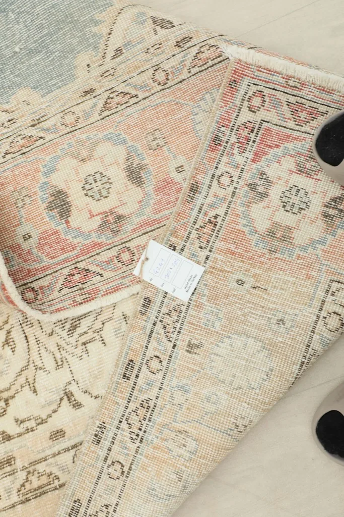Reverse side of the rug with a label, showing the hand-knotted wool on cotton foundation