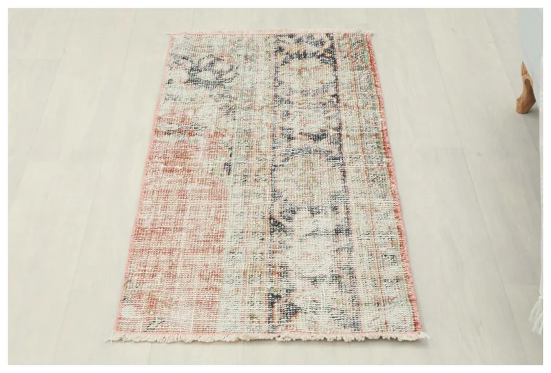 Full top view of the faded rust and blue hand-knotted vintage Anatolian rug on a white background.