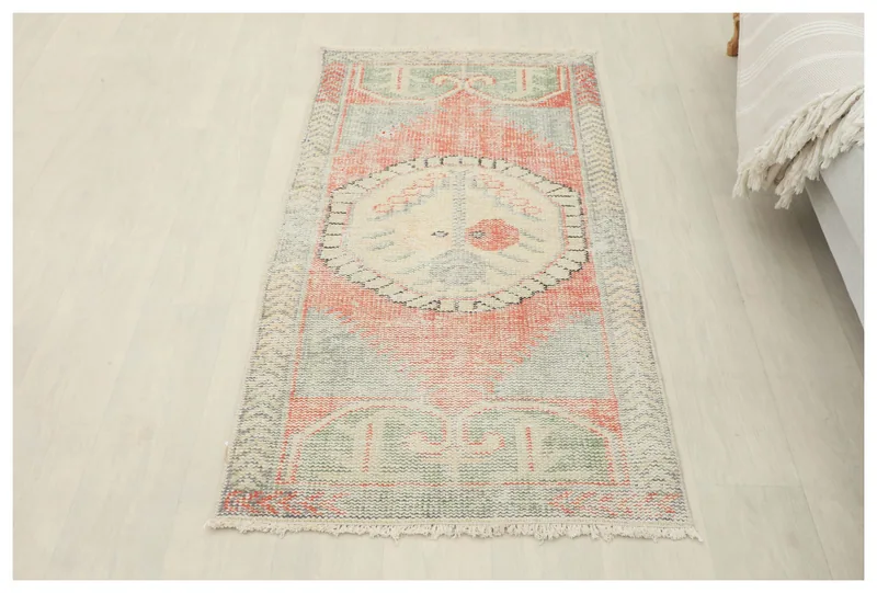 Full top view of the 2x5 vintage Anatolian rug with orange, green, and ivory colors on a white floor.