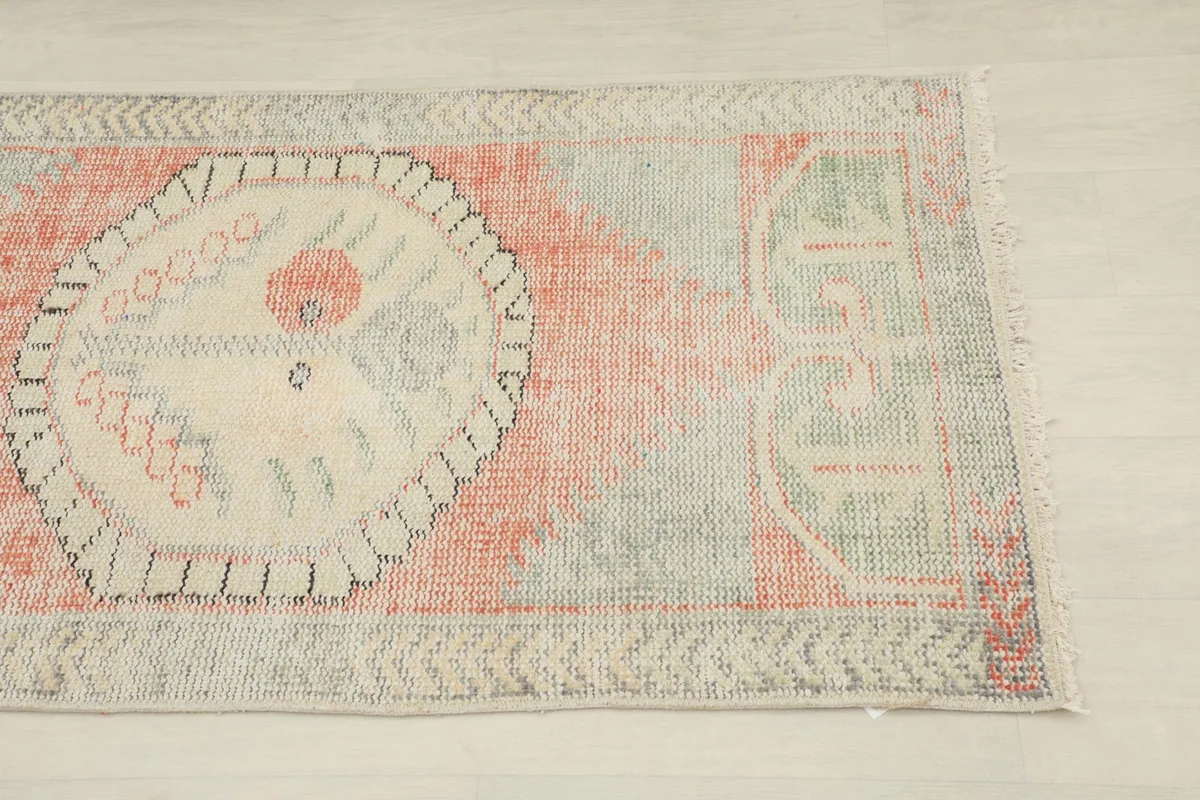 Close-up detail of the rug's central medallion and a portion of the orange field.
