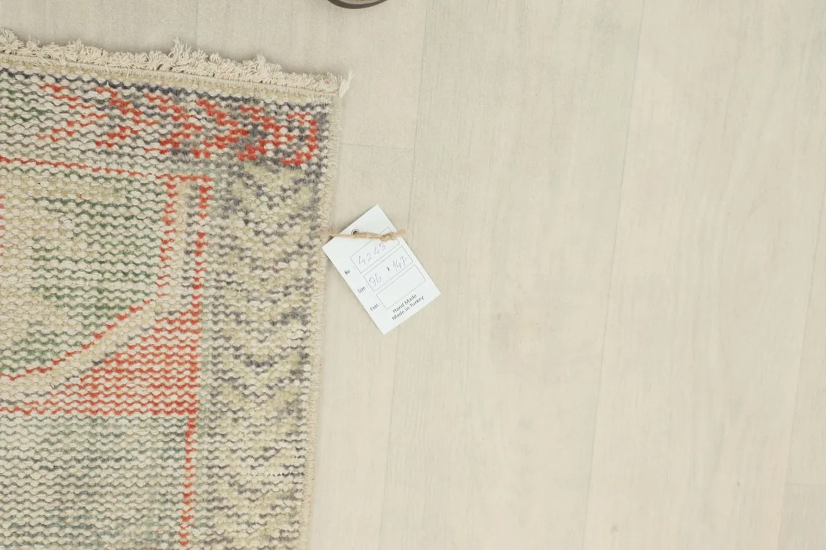 Close-up of the rug's back with a product tag, showing the reverse side's knotting.