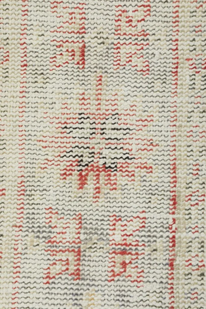 Close-up of the low wool pile, revealing the intricate knotting and color variations of the rug