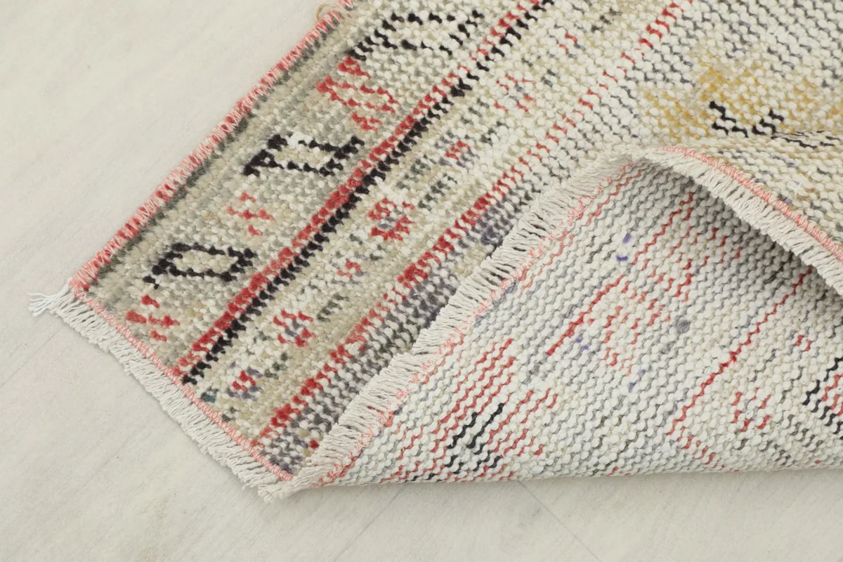 View of the rug's reverse side, showing the hand-knotted wool pile on a cotton foundation