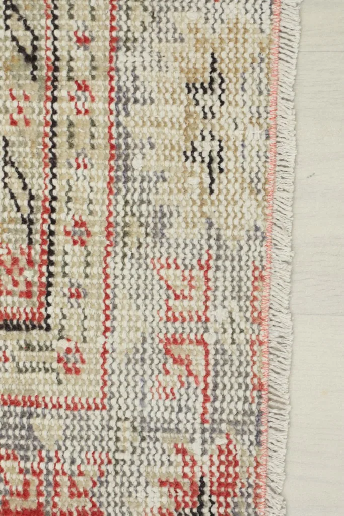 Close-up of the rug's edge, showing the short fringe and the tightly woven cotton foundation