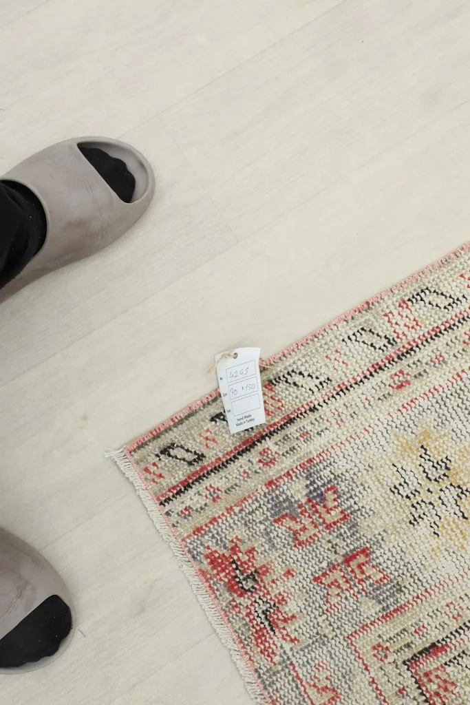 Overhead view of a foot next to the rug, providing a sense of scale and texture
