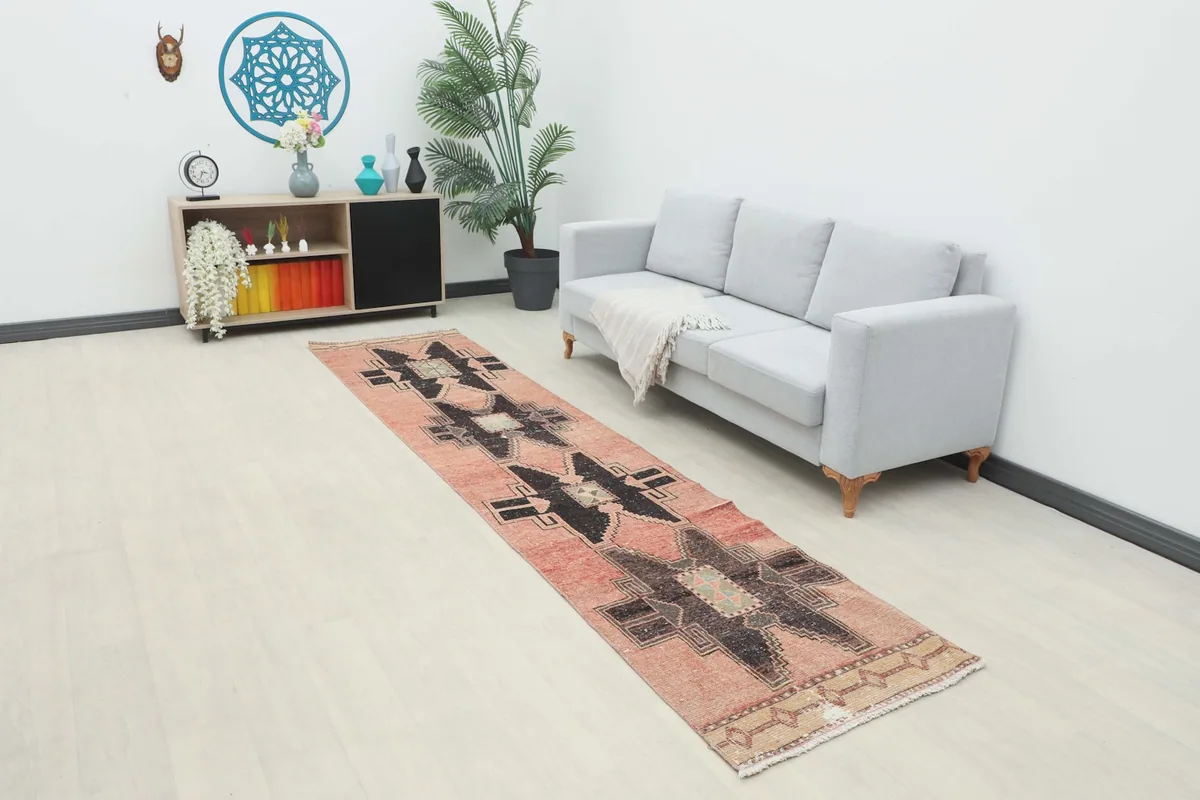 Runner rug displayed in a room setting with a sofa and shelving, showing its scale and fit.