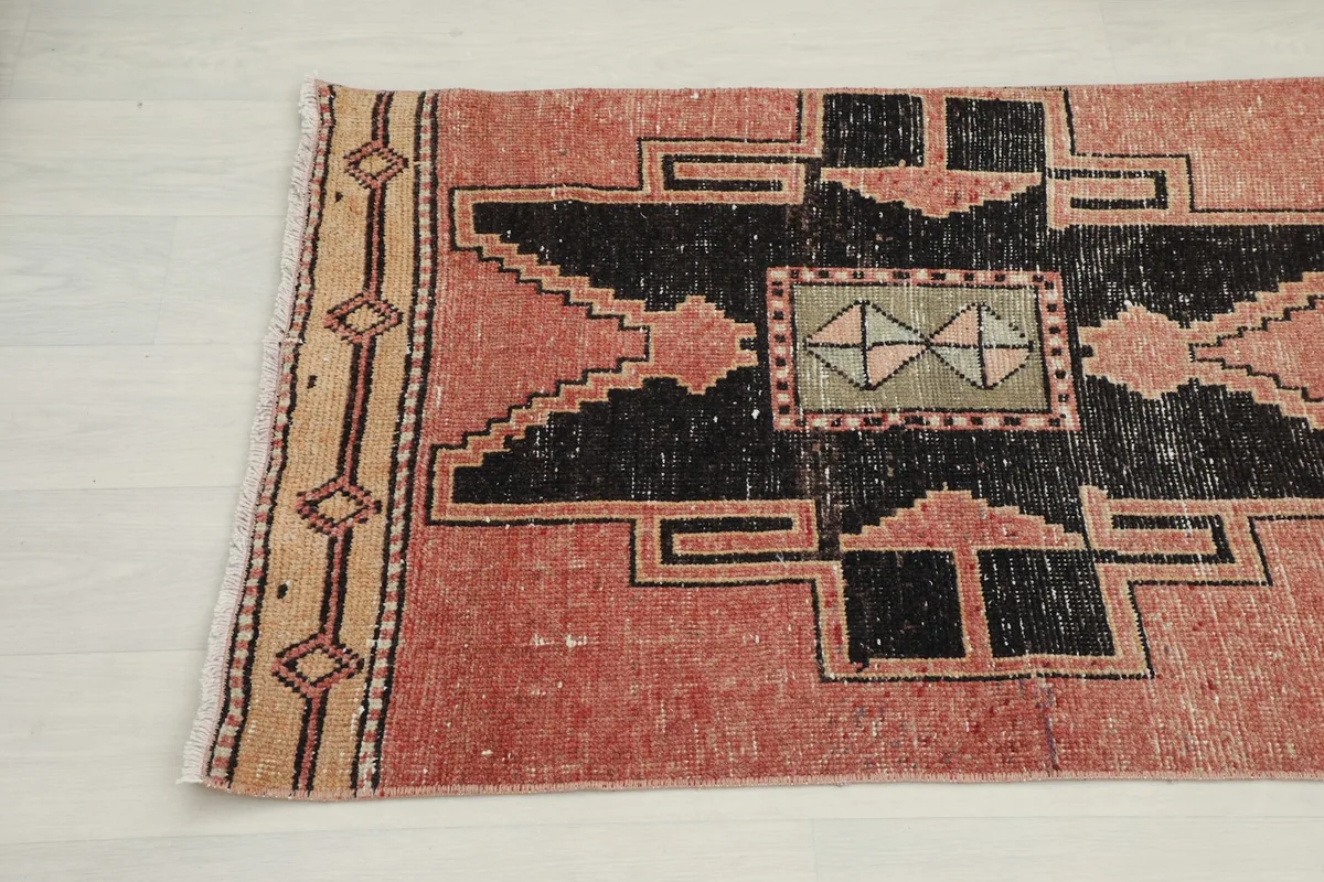 Close-up of the other end of the runner, detailing the beige border design and central black geometric motif.