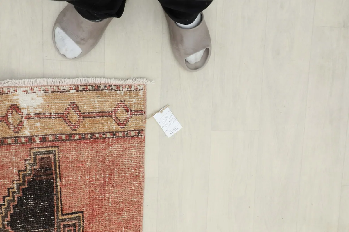 Overhead view of a section of the runner with feet in slippers for scale, showing the tag.