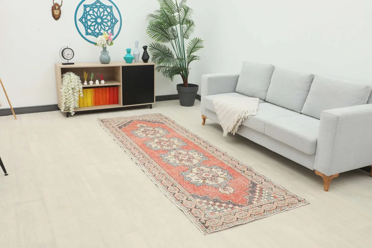Vintage rust runner displayed in a modern living space with a gray sofa and wooden cabinet