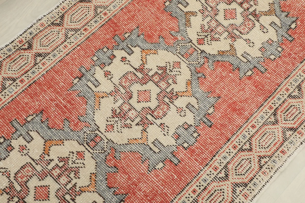 Detailed view of a central geometric medallion with rust, gray, and ivory tones