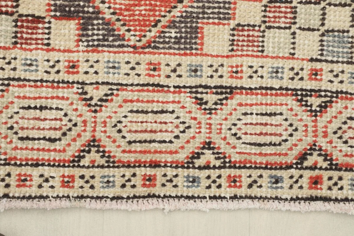 Close-up of the runner's border design and short, natural fringe