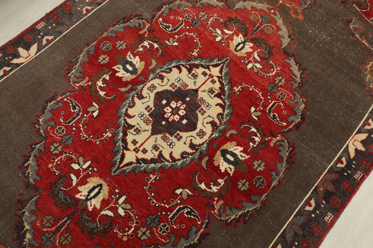 Detailed view of the central red medallion with ivory and gray accents