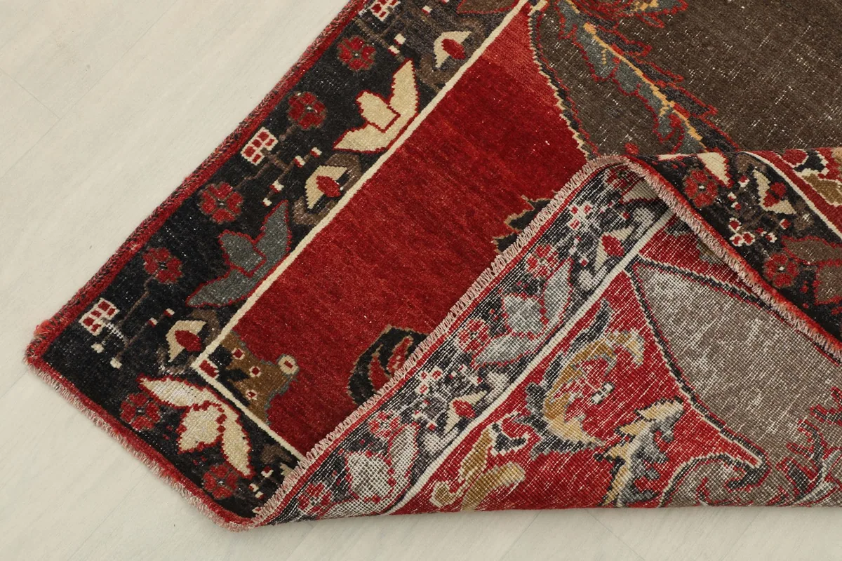 Corner of the rug folded back, showing the wool pile and cotton foundation