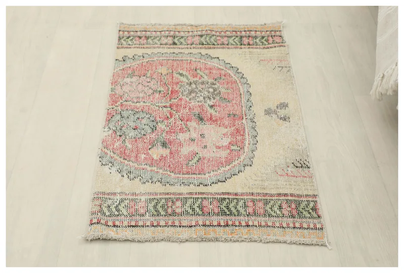 Full top view of the vintage Anatolian rug with a rose medallion on an ivory field.