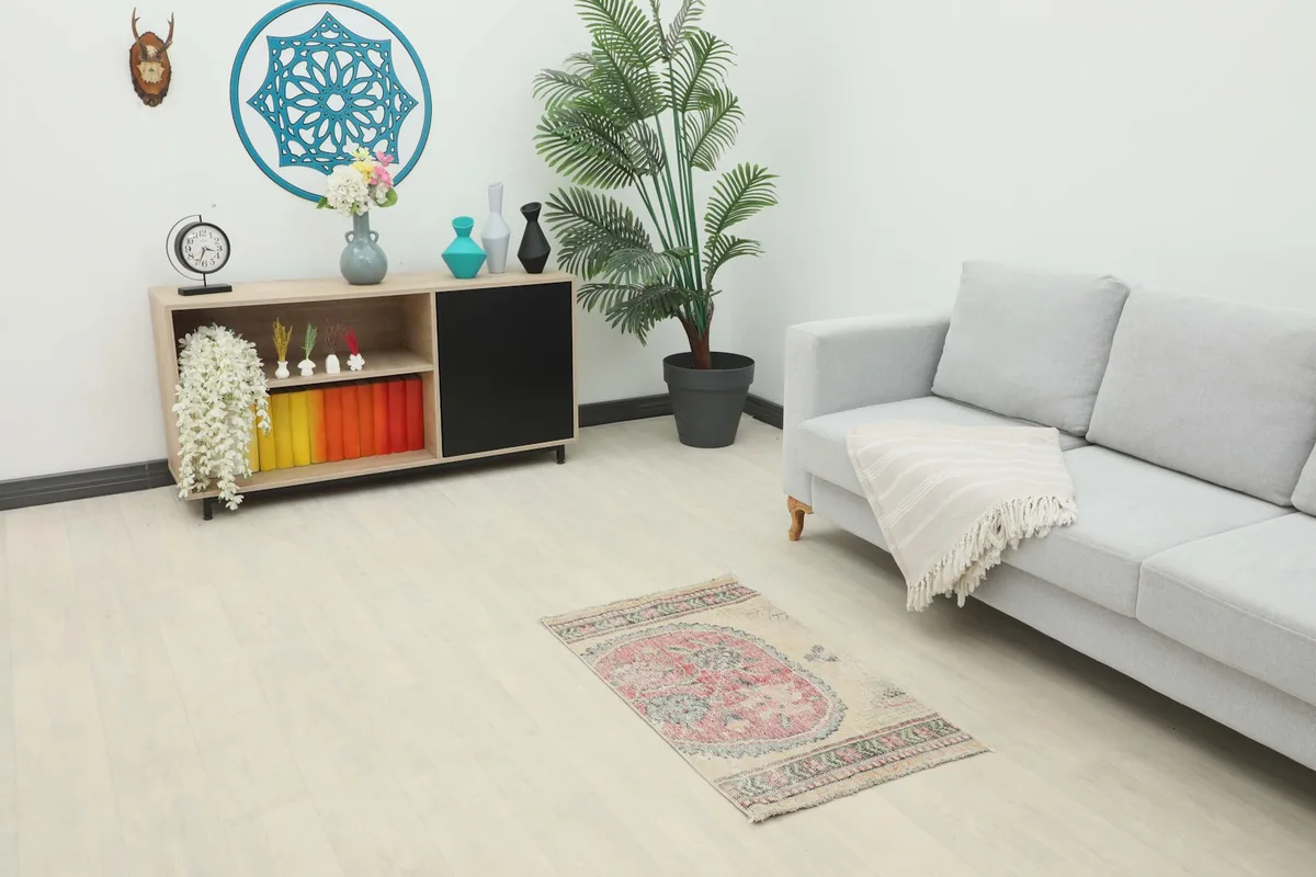 Vintage Anatolian rug placed in a modern living room setting, showcasing its mini size.
