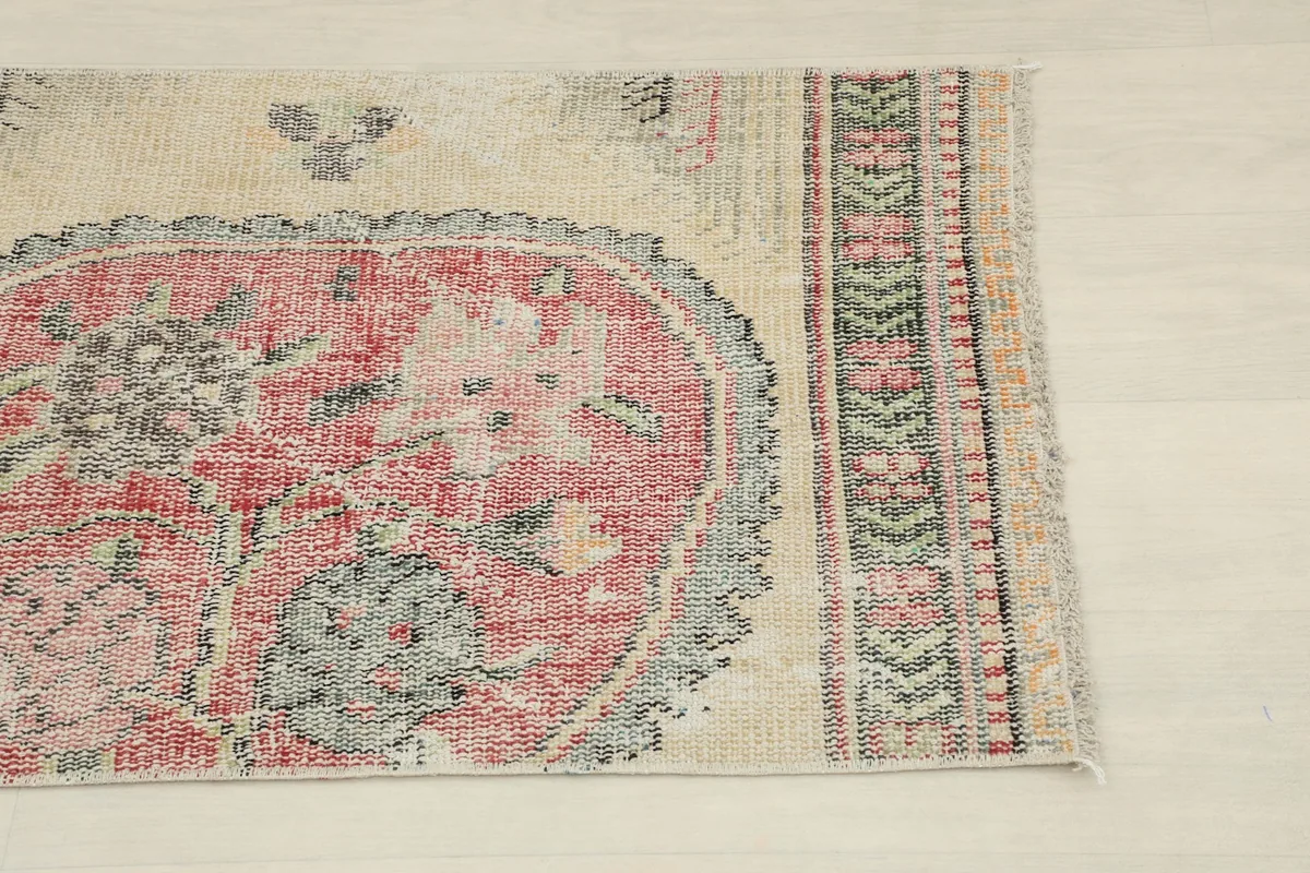Close-up of the rug's top left section, showing the medallion edge and geometric border.