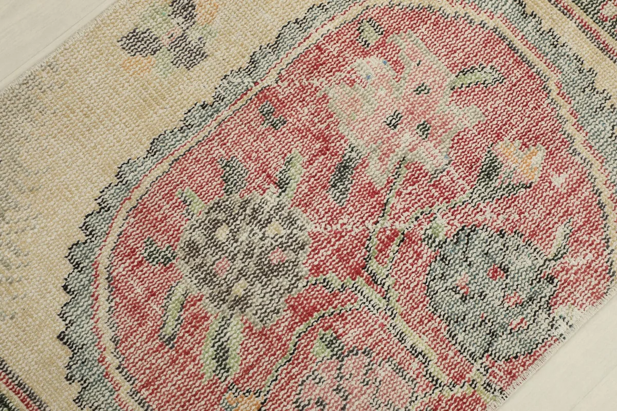 Detailed view of the central rose medallion with faded floral motifs and black accents.