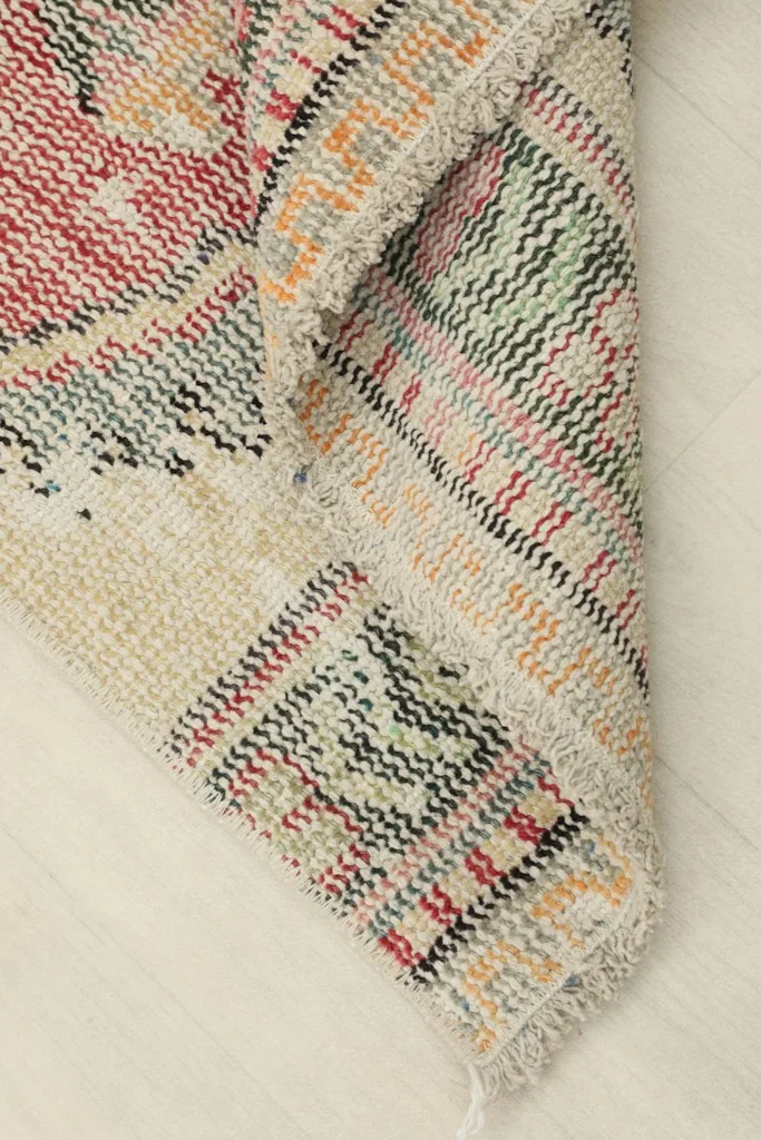 View of the rug's underside, showing the cotton foundation and hand-knotted construction.