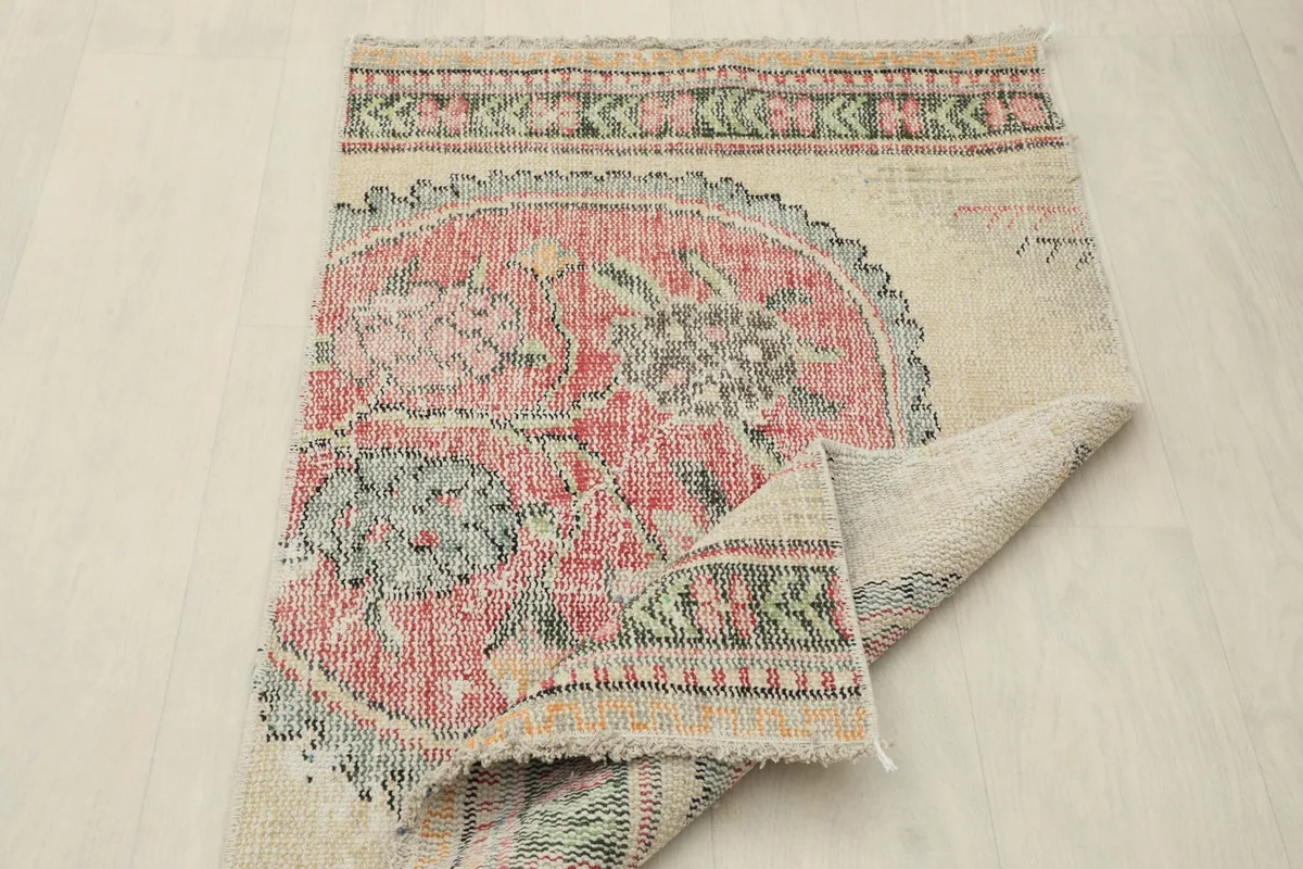 Rug partially folded, illustrating its flexibility and thickness of the vintage wool.